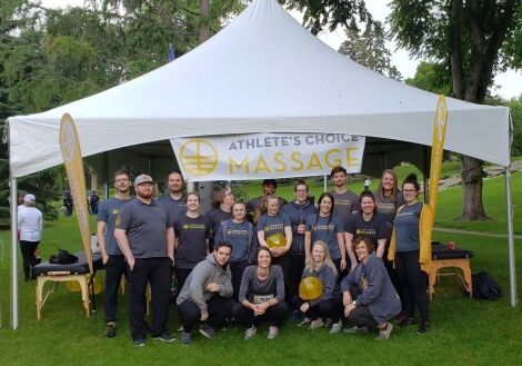 Sherwood Park massage therapy team from Athlete’s Choice Massage gathered at a community event tent.